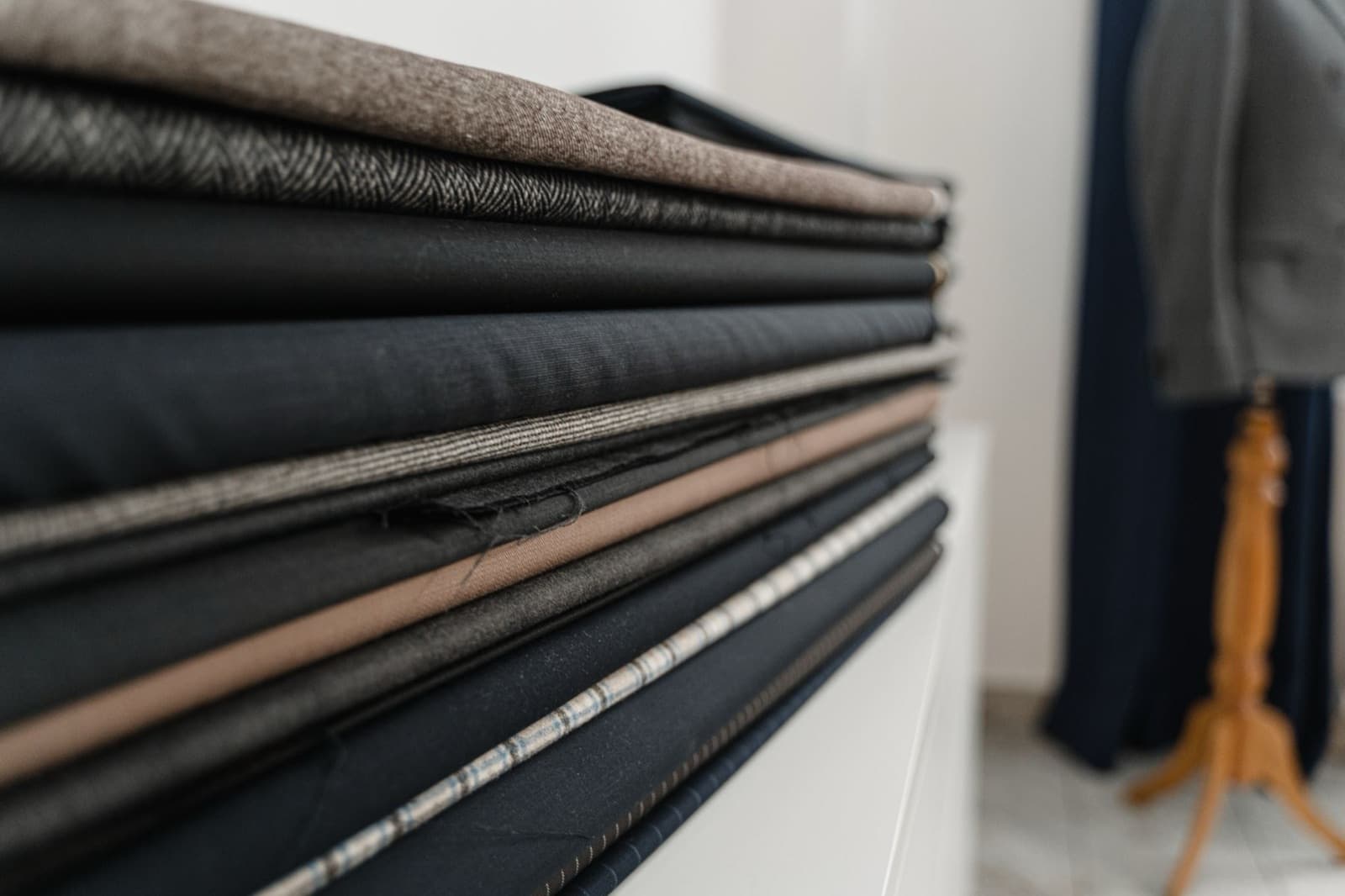 Stacked bolts of folded fabric in a tailor's workshop
